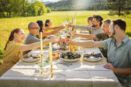 Party themes for adults with a group of people sitting outside having dinner.