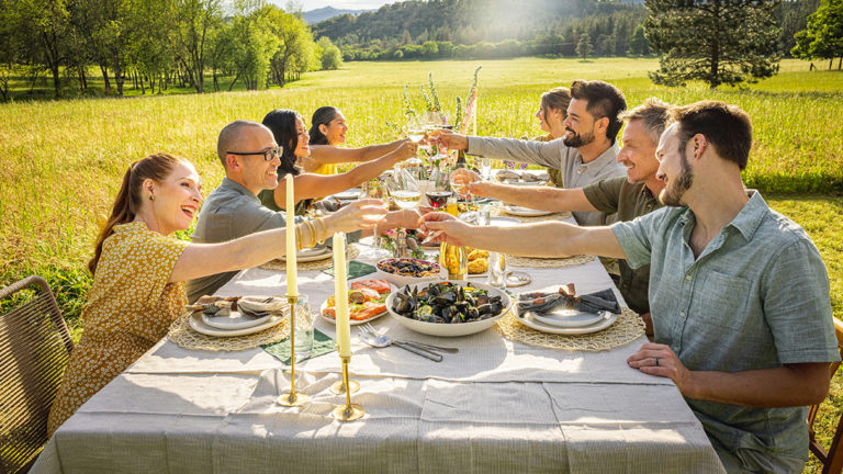 Party themes for adults with a group of people sitting outside having dinner.