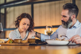 Comfort food with a man comforting a woman at a restaurant.