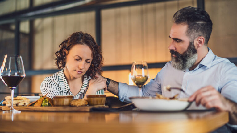 Comfort food with a man comforting a woman at a restaurant.