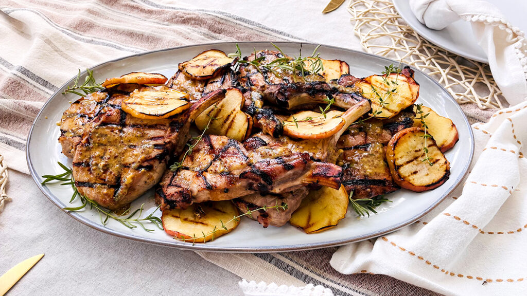 Pork chops with apples on a plate.
