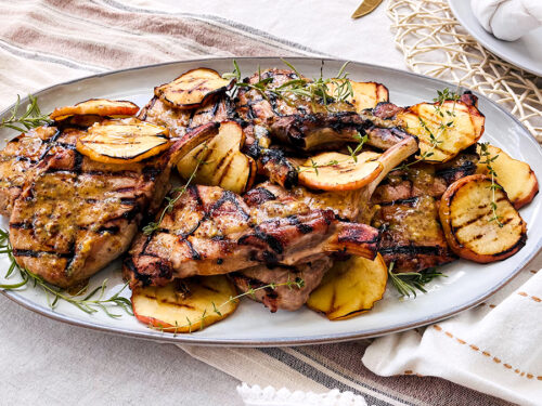 Pork chops with apples on a plate.