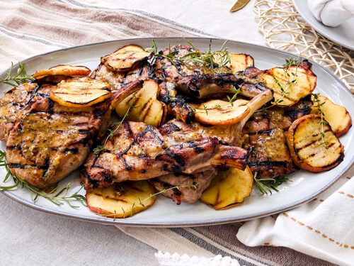 Pork chops with apples on a plate.