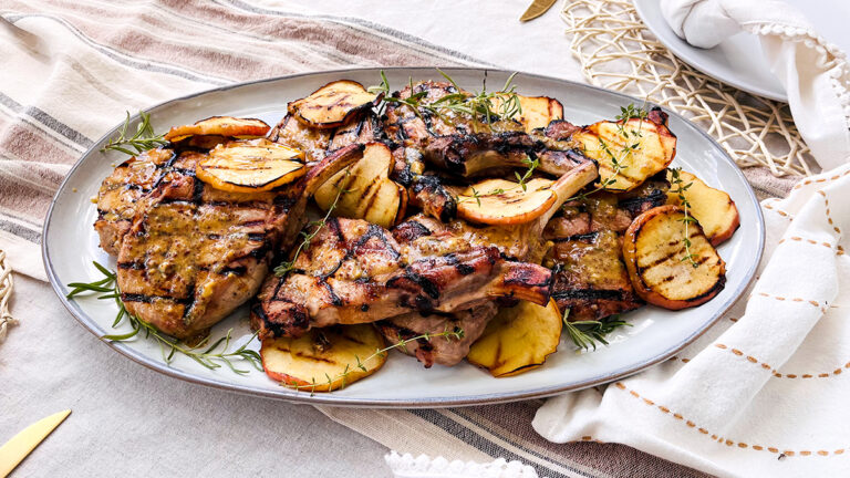 Pork chops with apples on a plate.