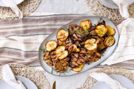 Pork chops with grilled apples on a plate.