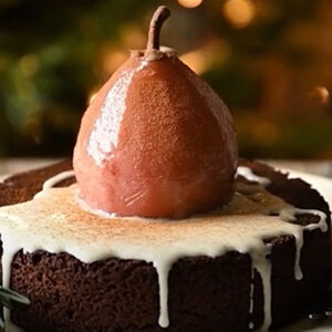 September recipes with a poached pear sitting on top of an iced cake.