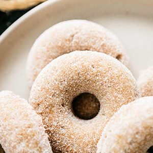 Fall recipes with apple donuts piled on a plate.