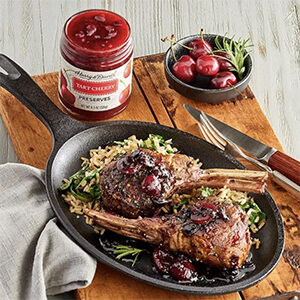 Fall recipes with lamb chops in a frying pan next to a jar of tart cherry chutney