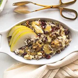 Fall recipes with a wild rice salad in a dish topped with sliced pears and cheese.