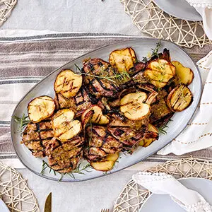 October recipes with a plate of cider-brined pork chops with sliced apples.