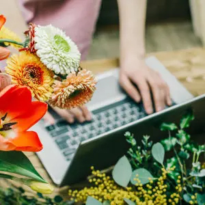 Office superstars with a closeup of a laptop and a bouquet of flowers.