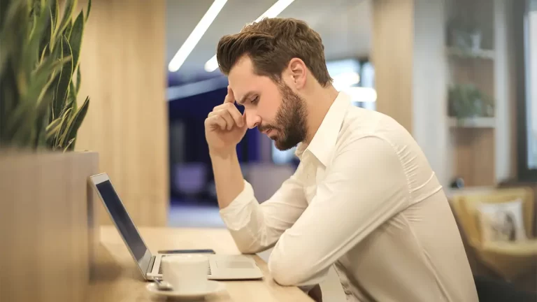 Photo of man looking at laptop.