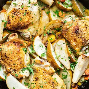 Pear recipes with a closeup of a pan full of braised chicken with pears.