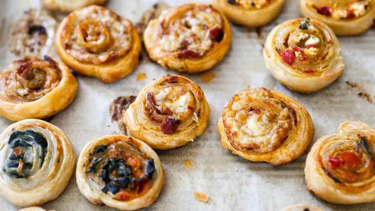 Puff pastry appetizers on a baking sheet.