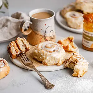 Pumpkin recipes with a pumpkin cinnamon roll on a plate.