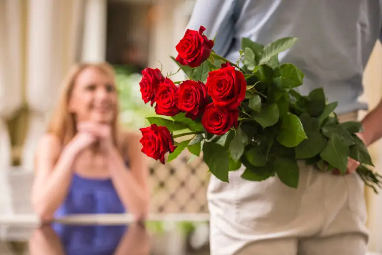 Sweetest Day Gifts. A man holding a bouquet of roses behind his back