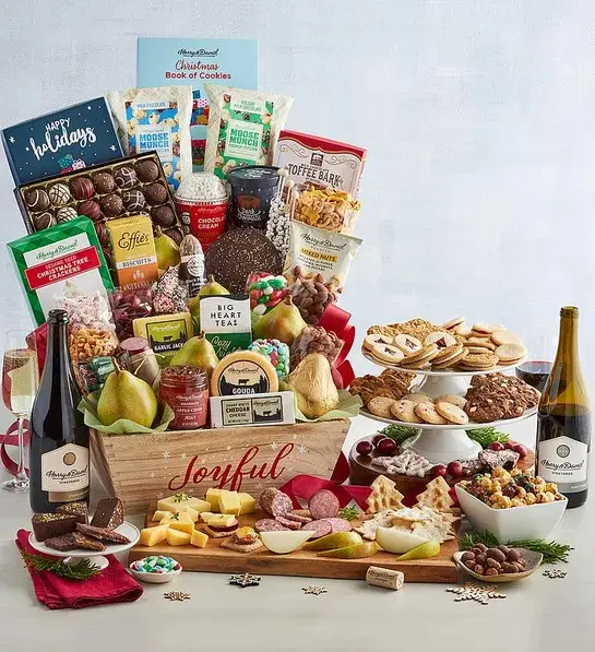 Best gifts with a Christmas gift basket full of sweet and savory snacks next to a bottle of wine.