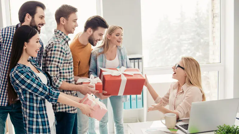 Boss's day gift ideas with a group of people at work presenting gifts to their boss.