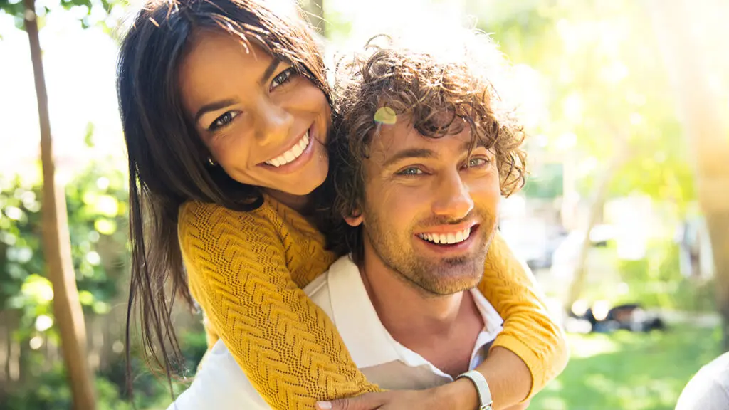 Gratitude with a couple hugging and smiling at the camera.