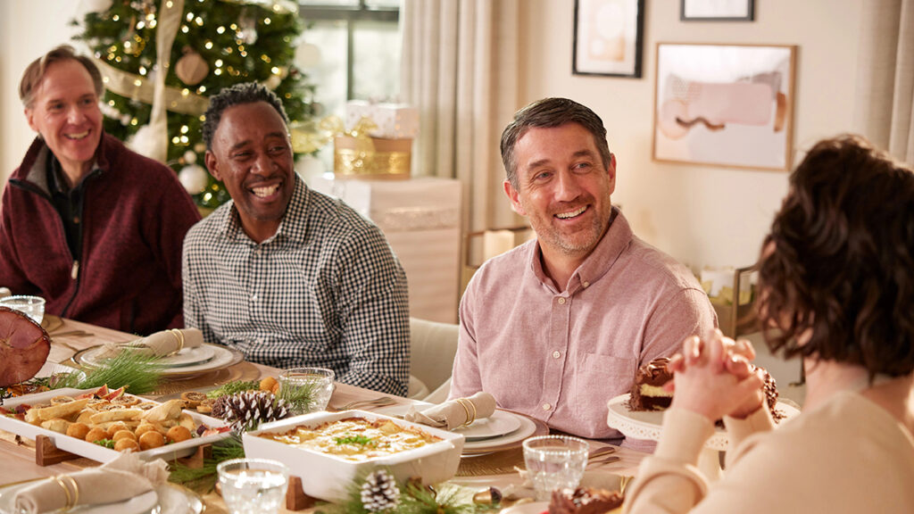 Practicing gratitude at the holiday table with four people laughing.