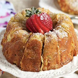 Thanksgiving recipes with a Bundt cake topped with sliced strawberries and powdered sugar.