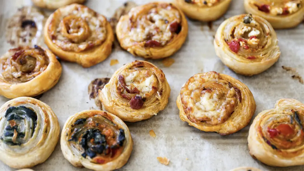 Thanksgiving recipes with a tray of savory puff pastry pinwheels.