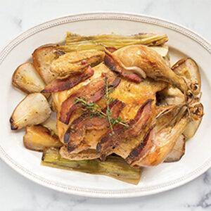 Thanksgiving recipes with a picture of a roast chicken with bacon, leeks and pears.