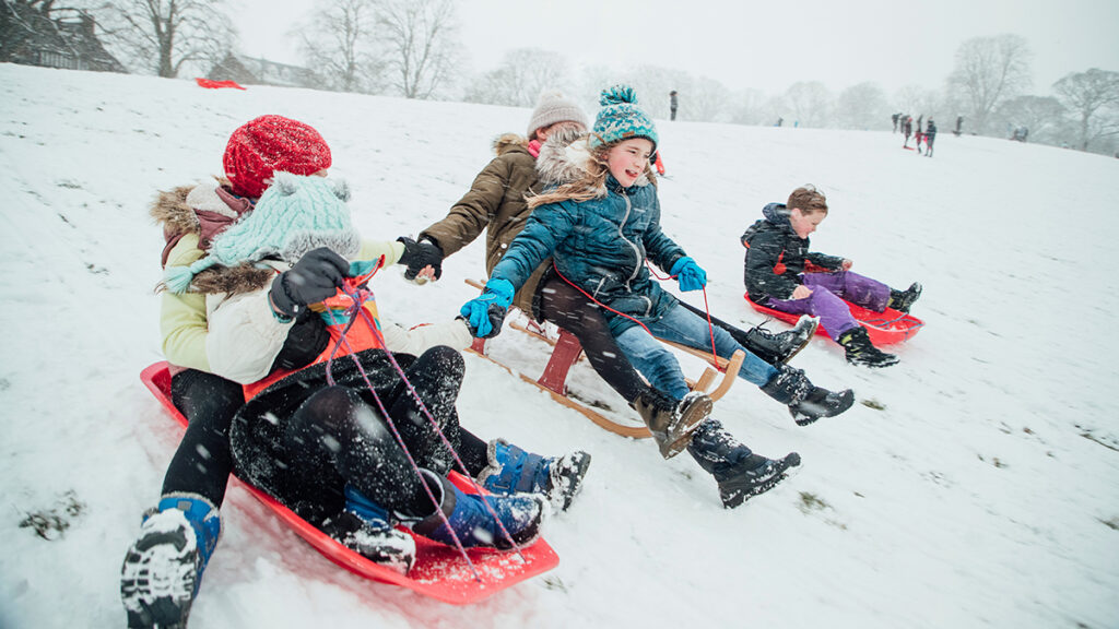 Why birthdays are special with a group of kids sledding down a hill.