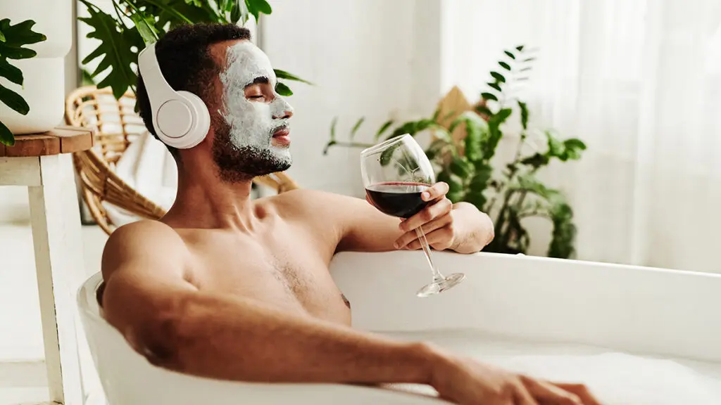 Why birthdays are special with a man in a tub listening to music, wearing a face mask, and drinking wine.