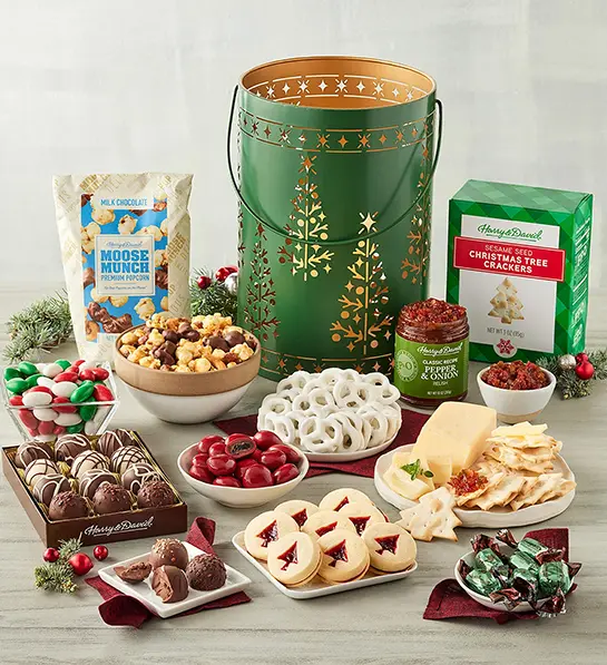 Christmas gift ideas for her with a Christmas lantern surrounded by cookies and other sweet treats.