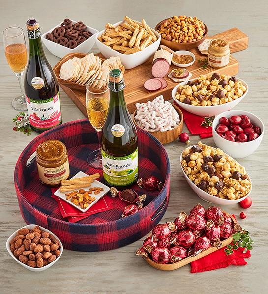 Christmas gift ideas for her with a selection of savory and sweet treats and two bottles of sparkling cider.