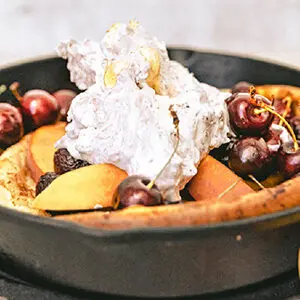 December recipes with a Dutch baby pancake covered with whipped cream and cherries.