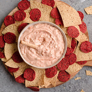 December recipes with a bowl of dip surrounded by multi-colored chips.