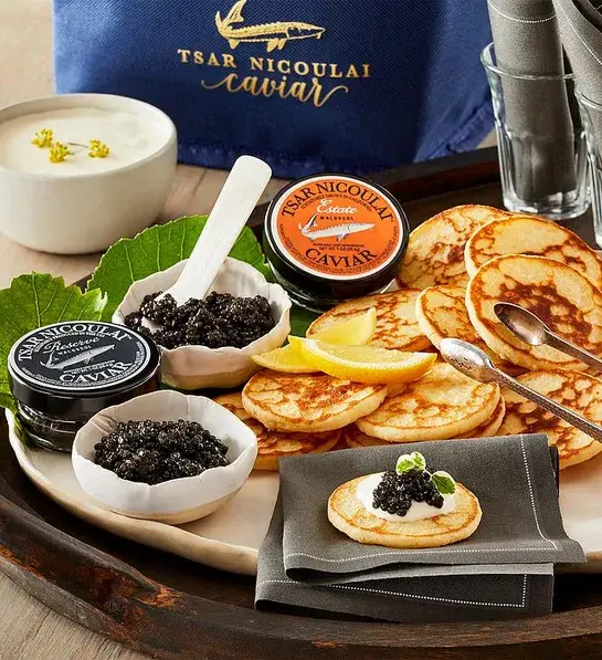 gifting matrix with a tray of caviar and small Russian pancakes.