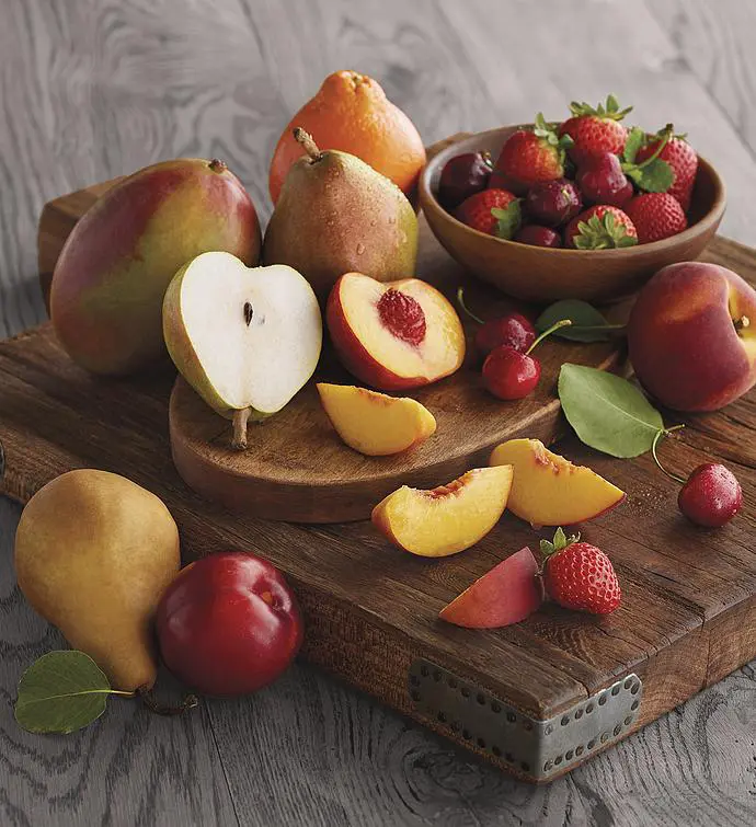 Gifting matrix with a collection of fresh fruit on a wooden board.