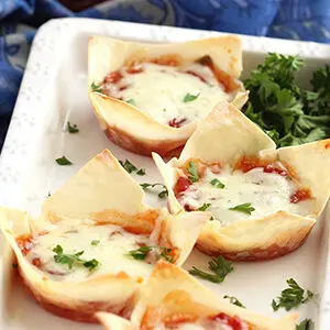 Pepper and onion relish wontons on a plate with garnish.