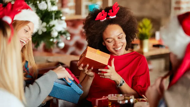 White elephant gift ideas with two women opening holiday gifts.