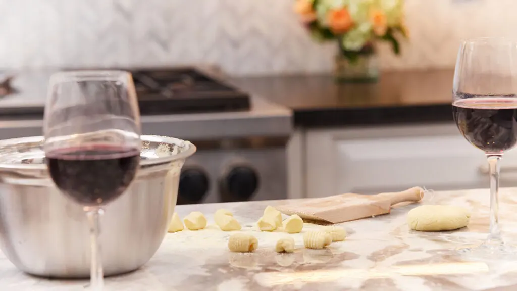 Alice's Table workshop with a counter covered in gnocchi and glasses of wine.