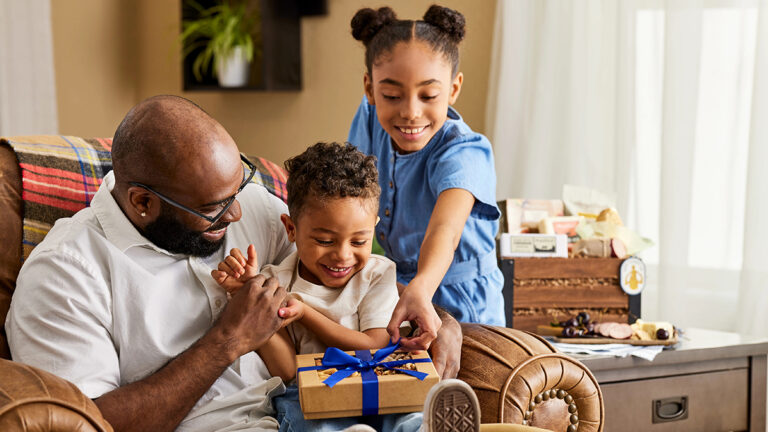 Best gifts for friends and family with a father and kids on his lap.