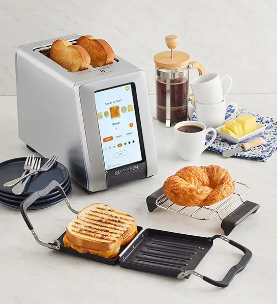 Revolution toaster surrounded by baked goods, coffee and more.