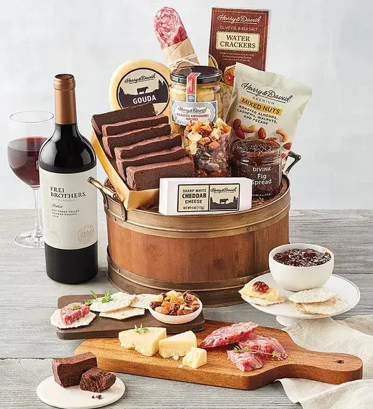Best gifts with a barrel full of sweet and savory snacks next to a bottle of wine.