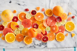Guide to oranges sliced and displayed on a marble counter top.
