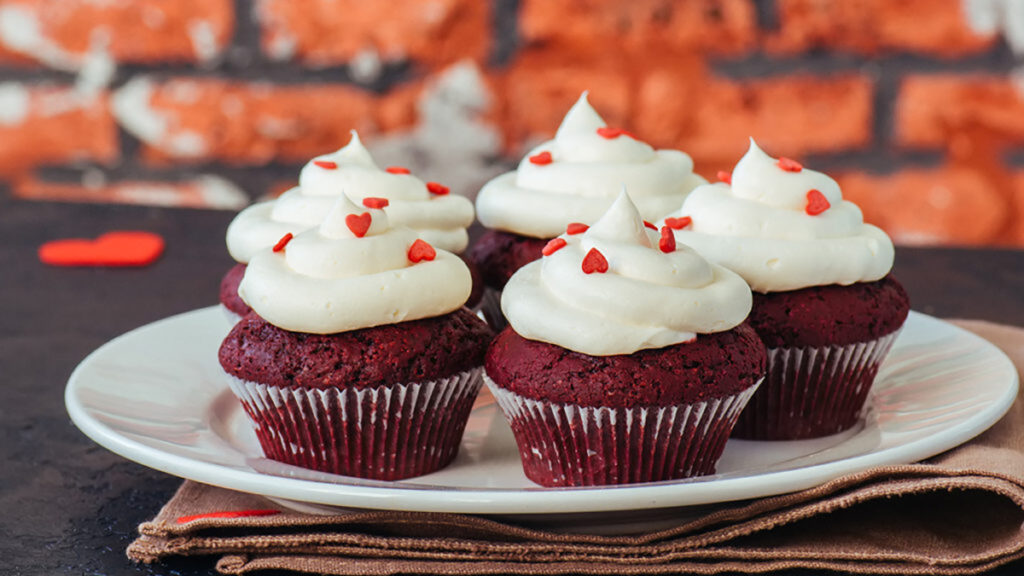History of red velvet cake with a plate of red velvet cupcakes.