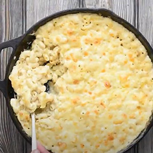 Romantic dinner ideas with a closeup of a cast-iron skillet full of mac and cheese.
