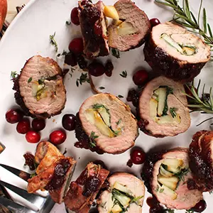 Romantic dinner ideas with a closeup of stuffed pork tenderloin on a plate.