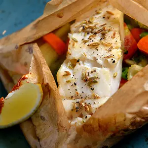 Salmon recipes with a piece of cooked salmon. in parchment paper with vegetables.