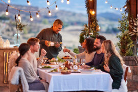 Wine trends with a group of people sitting at a table eating dinner and drinking wine outside.