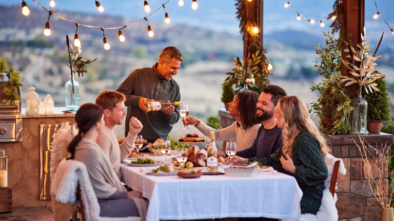 Wine trends with a group of people sitting at a table eating dinner and drinking wine outside.