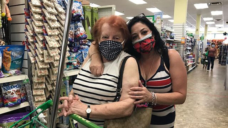 Caregiver story with two women looking at the camera in the aisle of a store.