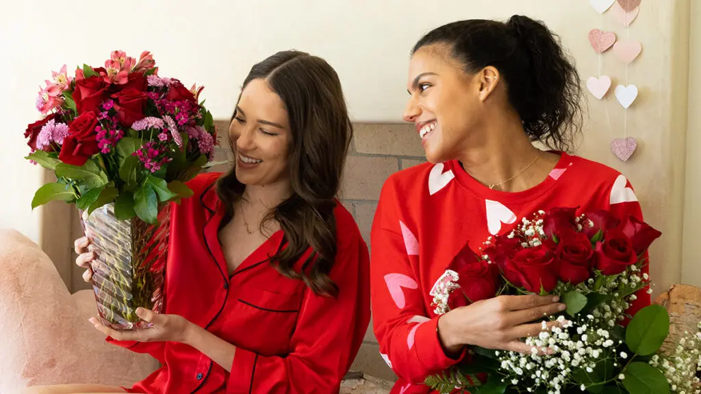Friendship songs with two women wearing red and holding flowers.